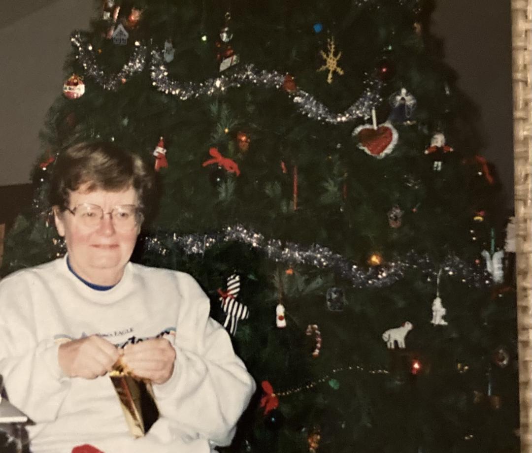 Eleanor Ford sits in front of a Christmas tree inside her home.