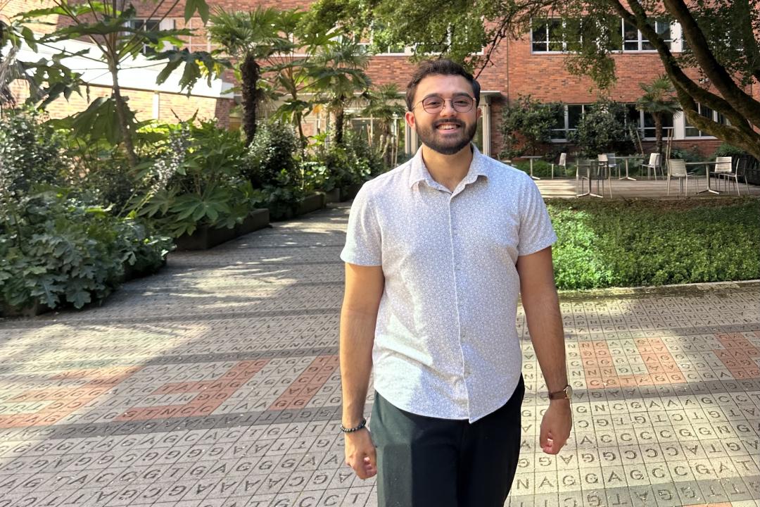 A man in a white shirt walks across campus