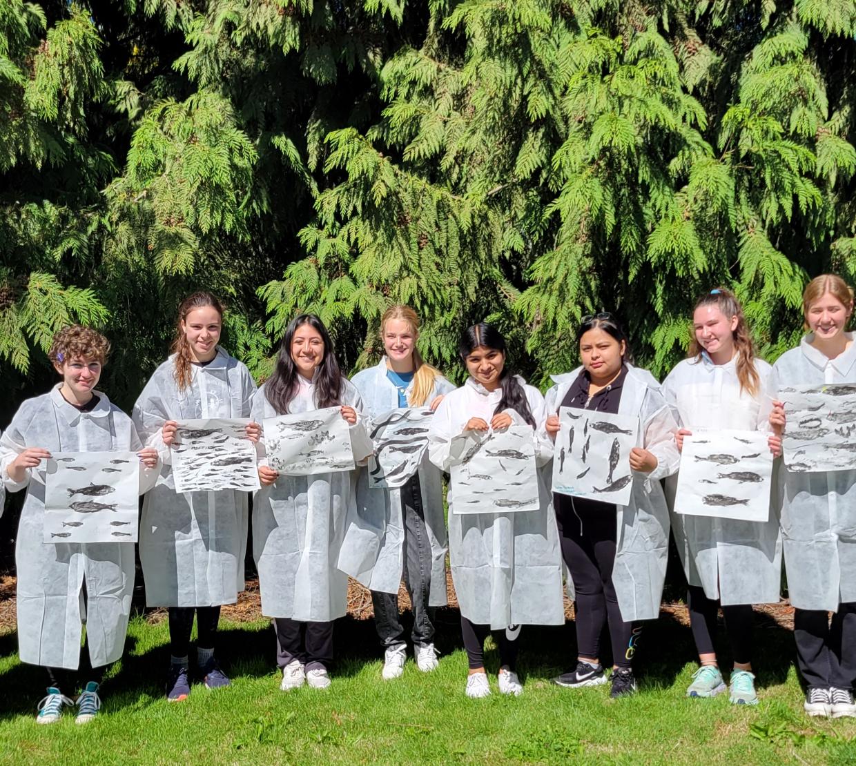 Students in lab coats pose for a group photo.