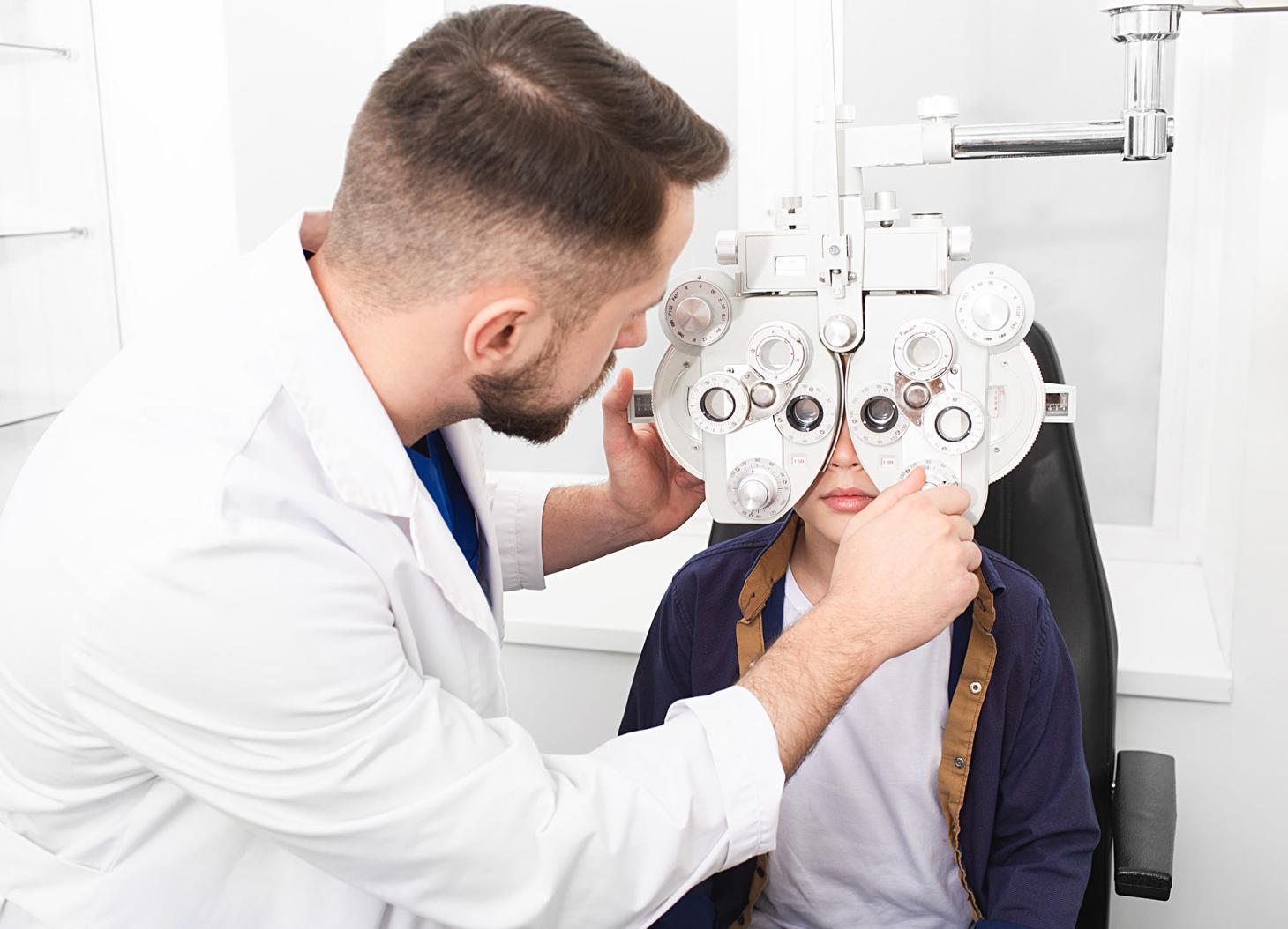 Eye doctor giving exam to child