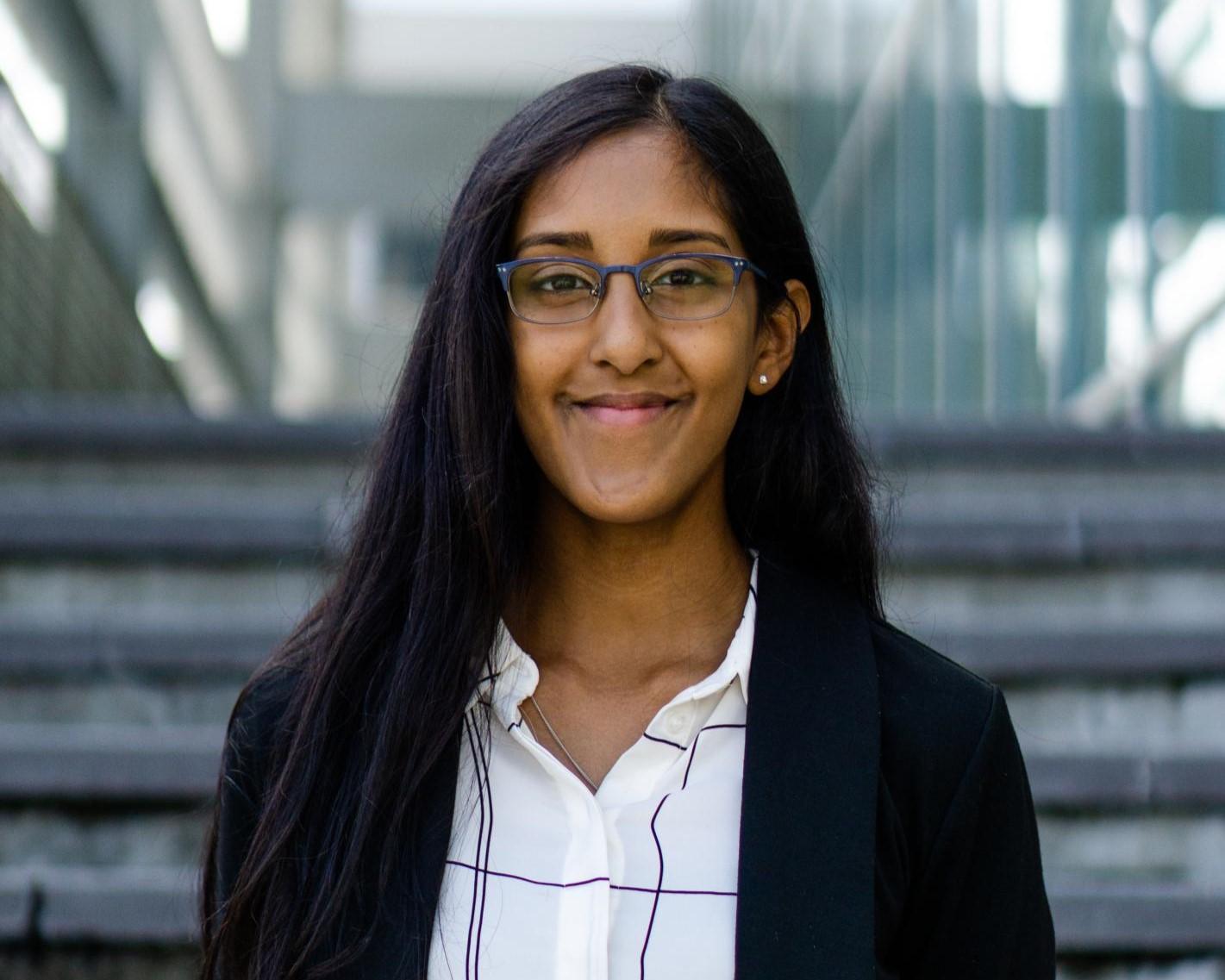 Nilanjana Das standing smiling in front of a stairway.