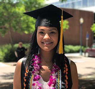 Chloe Villagomez wearing a grad cap and gown for graduation.
