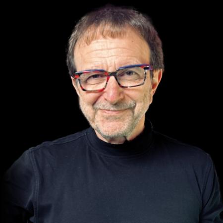 Vincent Racaniello wears a black shirt on a black background. He smiles slyly.