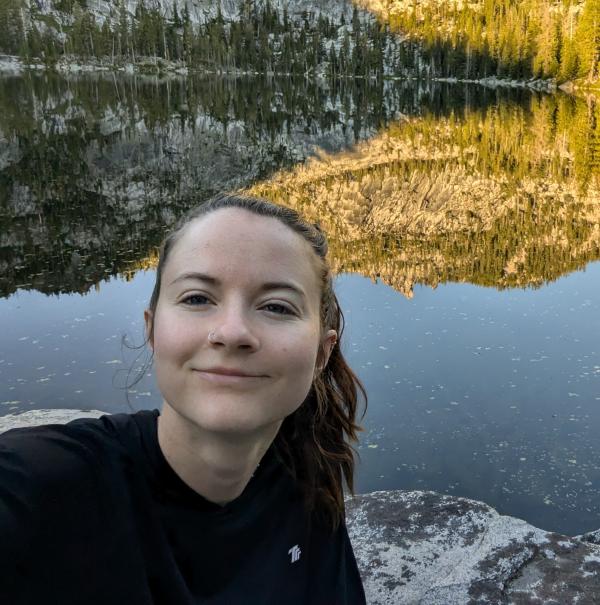 Photo of Bailey Morgan in front of a lake reflecting the landscape