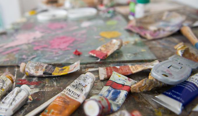 paint tubes and palettes sitting on studio table