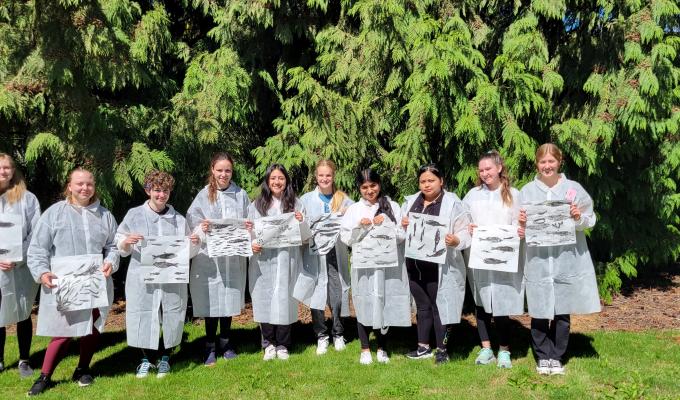 Students in lab coats pose for a group photo.