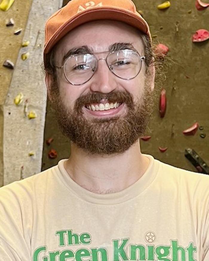 Kevin Rice in front of climbing wall