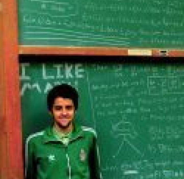 Chemistry and Physics major Collin Muniz in front of chalkboard