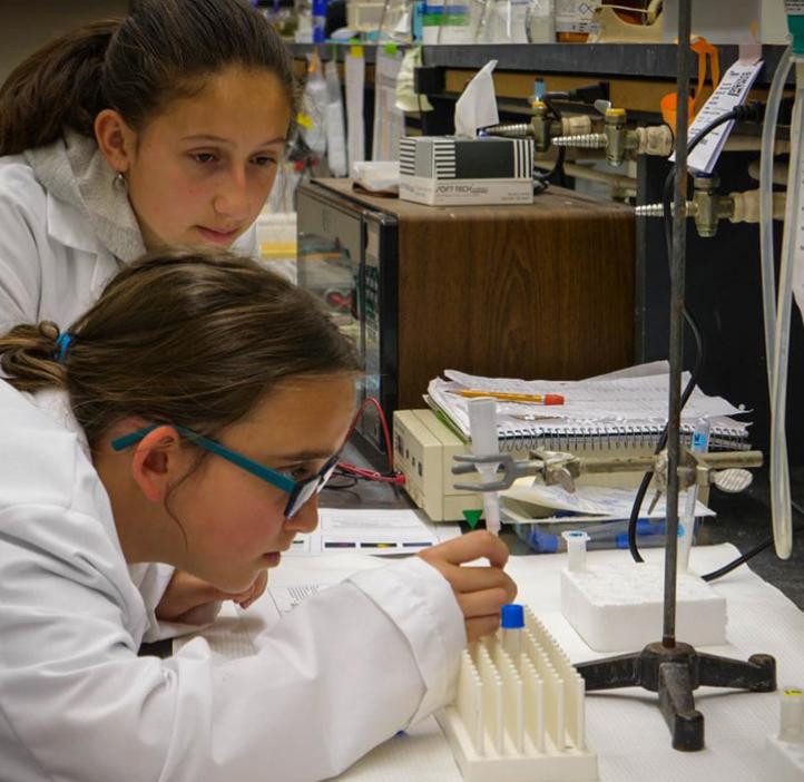 Middle school students working with lab equipment.