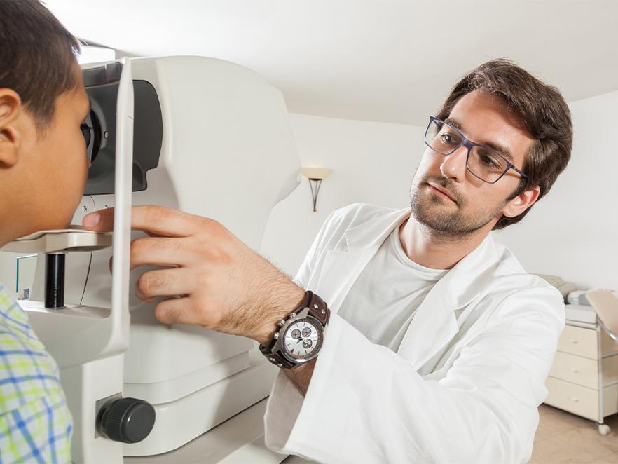 Optometrist giving eye exam to child